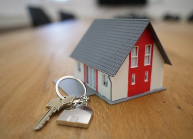 A model house and keys on an agent's desk