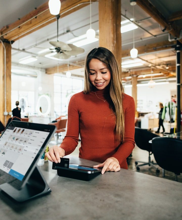 A member of staff taking a card payment at a point-of-sale terminal